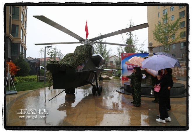 小區(qū)突然出現(xiàn)“飛機(jī)坦克”，其中殲15艦載戰(zhàn)斗機(jī)一架、99式主戰(zhàn)坦克一輛、武直-10武裝直升機(jī)一架，吸引了眾多市民雨中圍觀、合影。